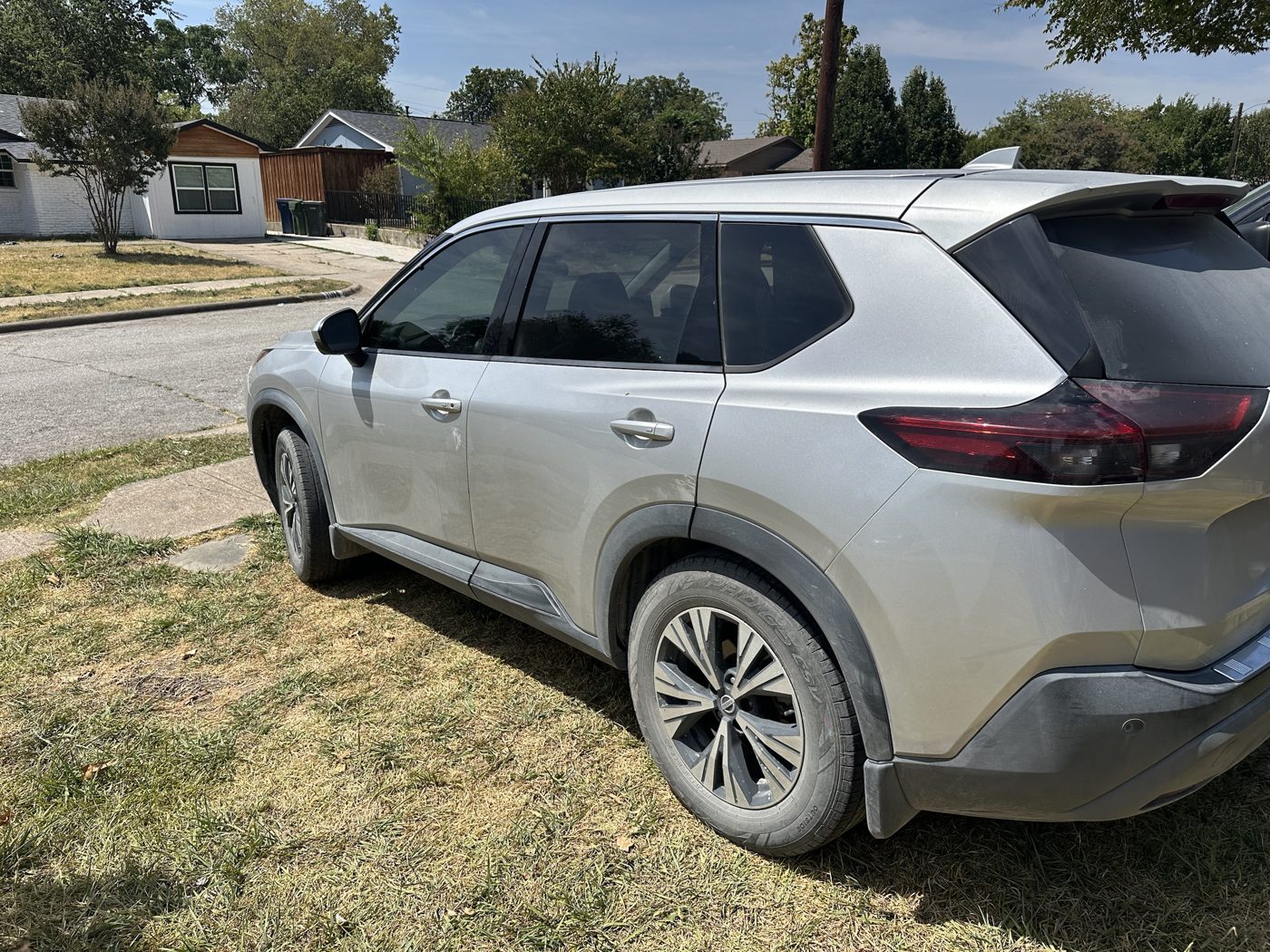 Silver Nissan Rogue SUV covered in dust with dirty wheels, before detailing
